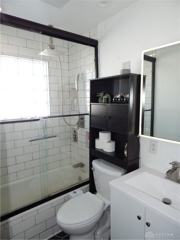 full bathroom with shower / bath combination with glass door, toilet, and vanity