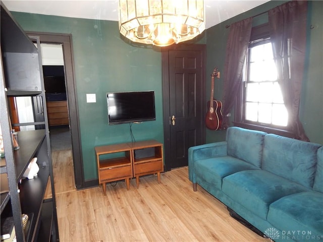 living room featuring an inviting chandelier and light wood-type flooring