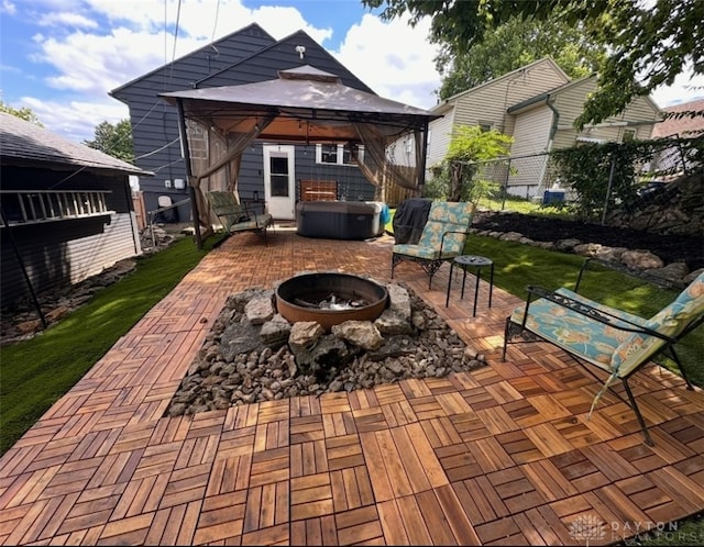 view of patio featuring a gazebo, a hot tub, and a fire pit