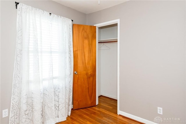 unfurnished bedroom with hardwood / wood-style floors and a closet