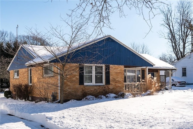 snow covered property featuring covered porch