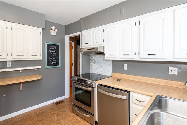 kitchen with light tile patterned floors, backsplash, white cabinets, appliances with stainless steel finishes, and sink