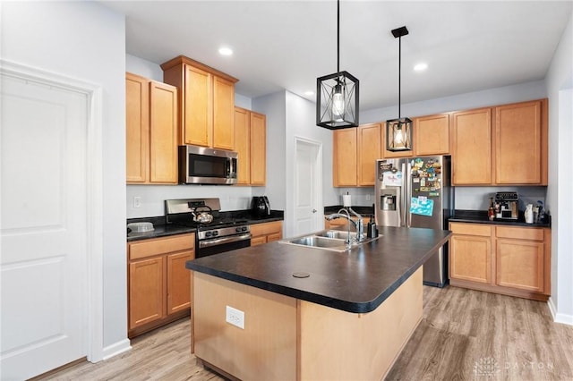 kitchen with hanging light fixtures, stainless steel appliances, light hardwood / wood-style floors, a kitchen island with sink, and sink