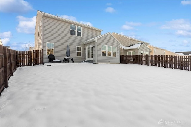 view of snow covered rear of property