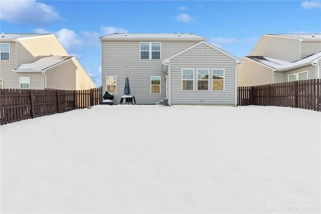 view of snow covered rear of property