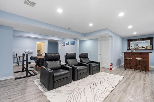 home theater room featuring bar and light hardwood / wood-style flooring