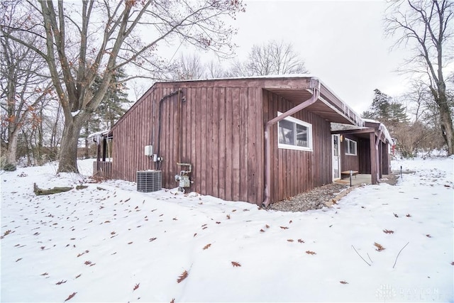 view of snow covered exterior featuring central AC unit