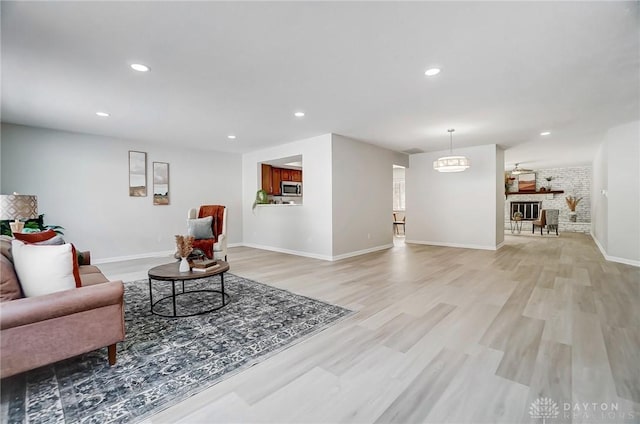 living room featuring brick wall and light hardwood / wood-style flooring