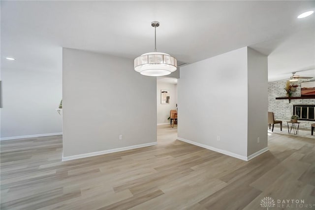 unfurnished room featuring light hardwood / wood-style flooring and a fireplace