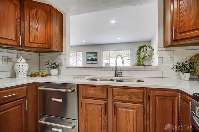 kitchen featuring sink, stainless steel dishwasher, and tasteful backsplash