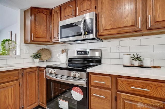 kitchen featuring stainless steel appliances and tasteful backsplash