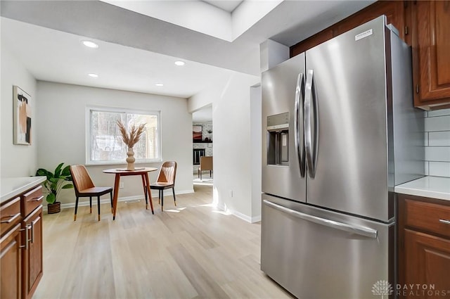 kitchen featuring stainless steel fridge with ice dispenser and light hardwood / wood-style flooring