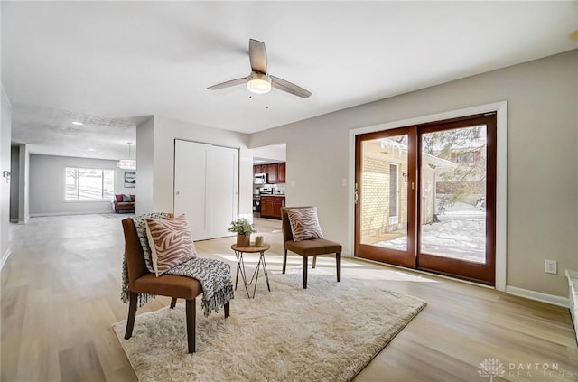 sitting room with ceiling fan and light hardwood / wood-style flooring