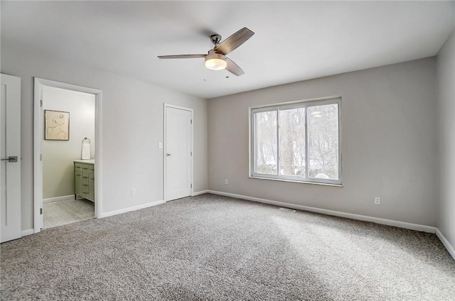 unfurnished bedroom with ceiling fan, ensuite bathroom, a closet, and light carpet