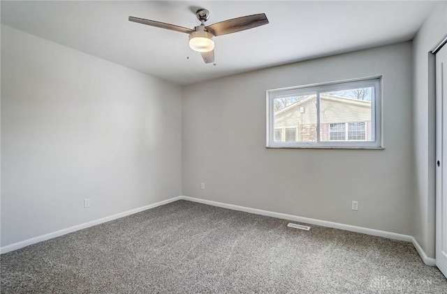 carpeted spare room featuring ceiling fan