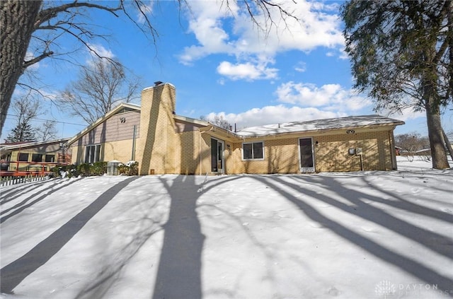 view of snow covered rear of property