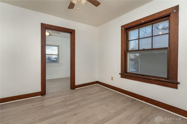 empty room with light wood-type flooring and ceiling fan