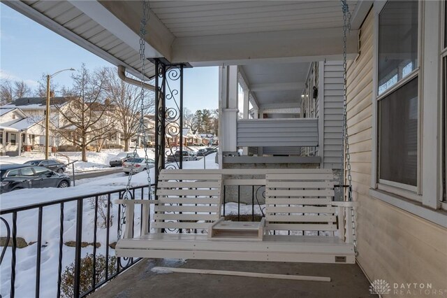 snow covered deck featuring a porch