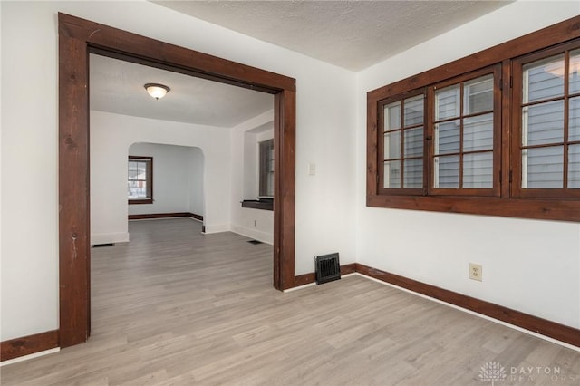 spare room with light hardwood / wood-style flooring and a textured ceiling