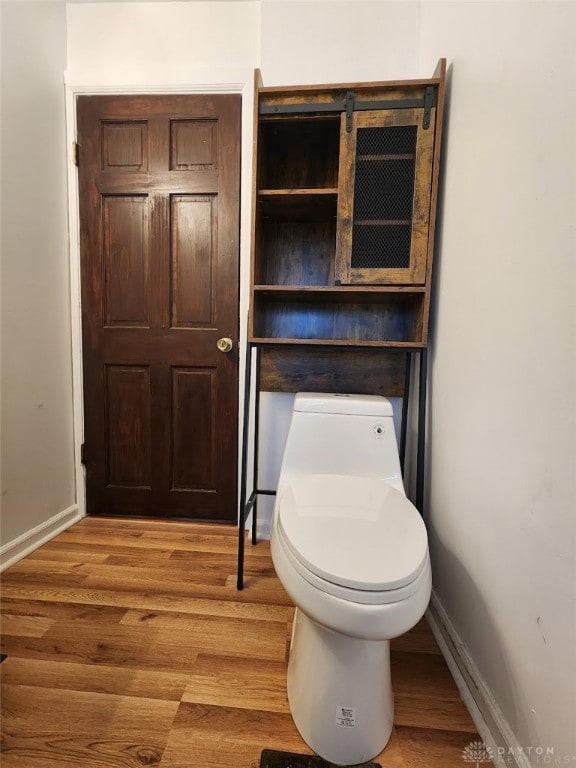 bathroom with toilet and hardwood / wood-style floors