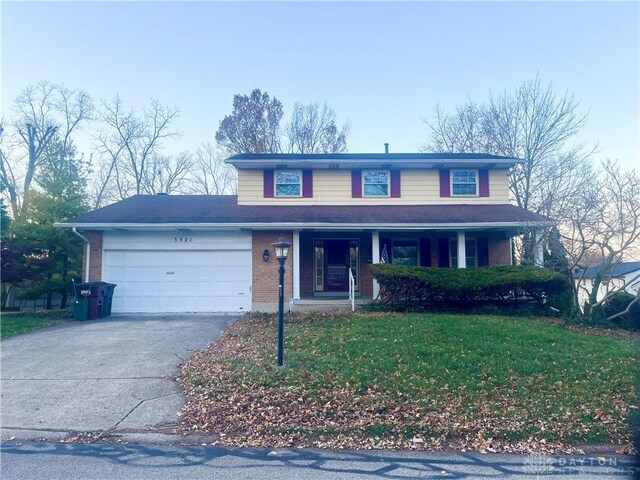 front of property with a front yard, a garage, and covered porch