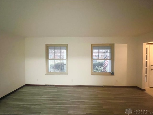 empty room featuring dark hardwood / wood-style flooring and plenty of natural light