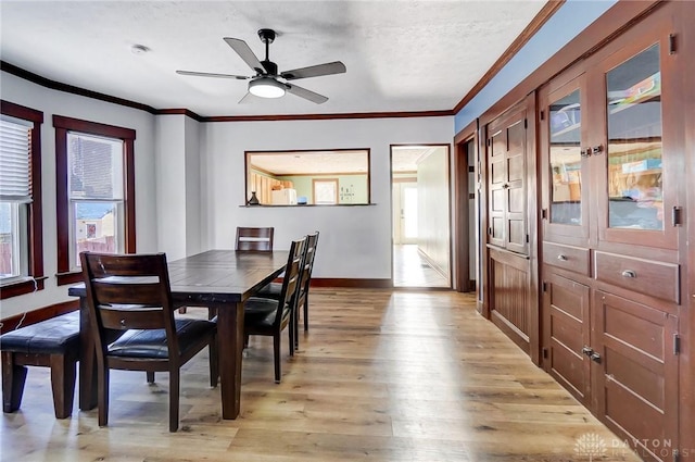 dining room featuring a textured ceiling, ceiling fan, light hardwood / wood-style floors, and a healthy amount of sunlight