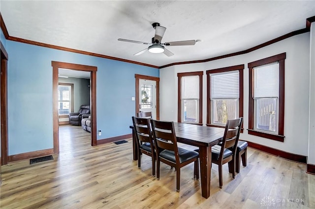 dining room featuring a healthy amount of sunlight, ceiling fan, light hardwood / wood-style flooring, and ornamental molding