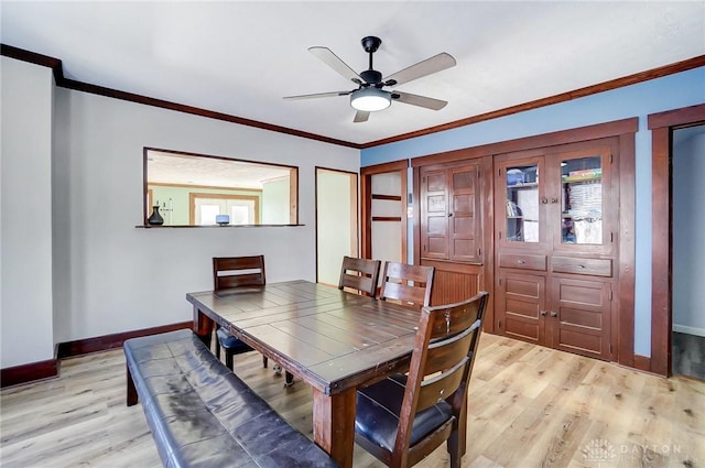 dining space with light wood-type flooring, ceiling fan, and crown molding