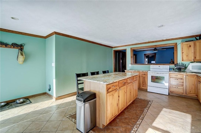 kitchen with white appliances, ornamental molding, a kitchen island, and light tile patterned floors