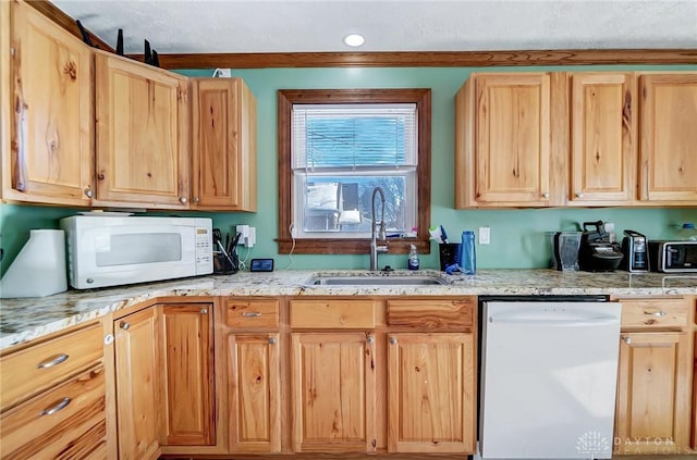 kitchen with white appliances, light stone counters, sink, and light brown cabinets