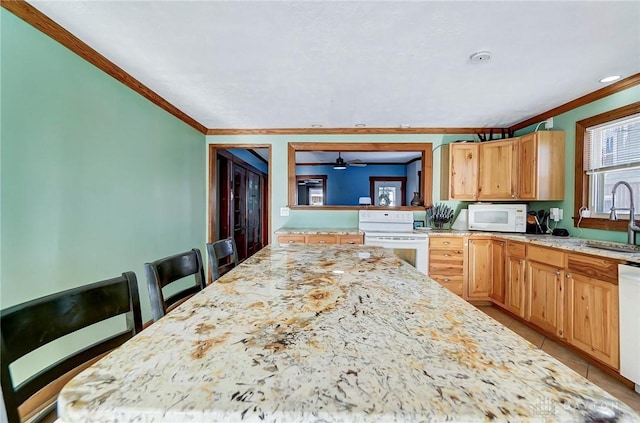 kitchen with white appliances, light brown cabinetry, light tile patterned floors, ornamental molding, and a kitchen breakfast bar