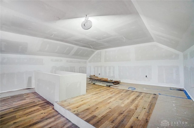 additional living space featuring lofted ceiling and hardwood / wood-style flooring