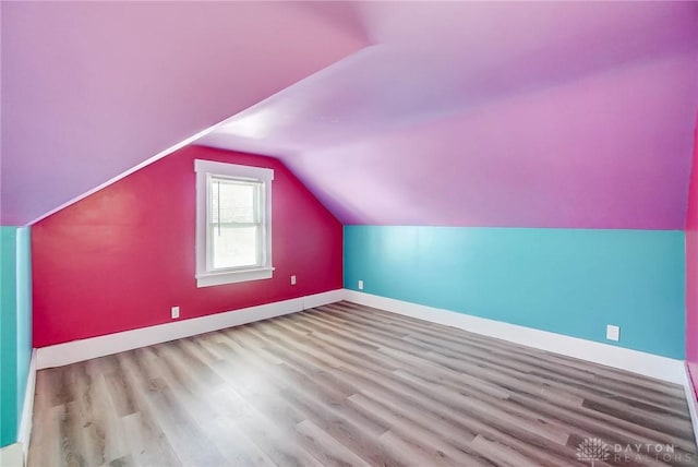 bonus room with light wood-type flooring and lofted ceiling