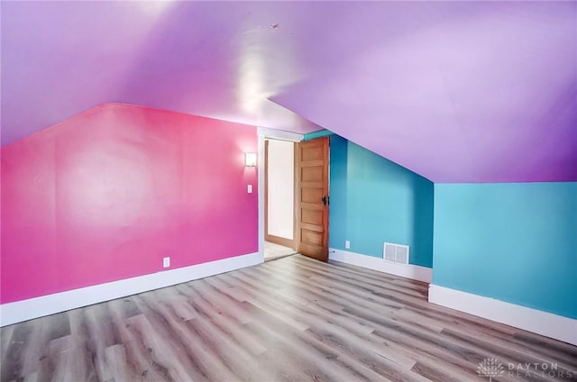 bonus room with light hardwood / wood-style flooring and lofted ceiling