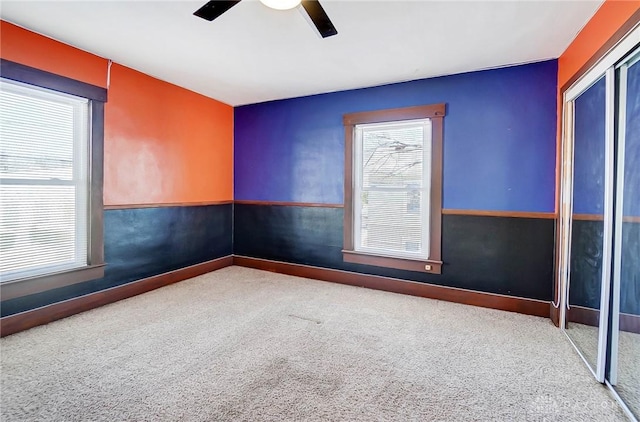 carpeted spare room featuring ceiling fan