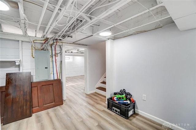 basement with electric panel and light wood-type flooring