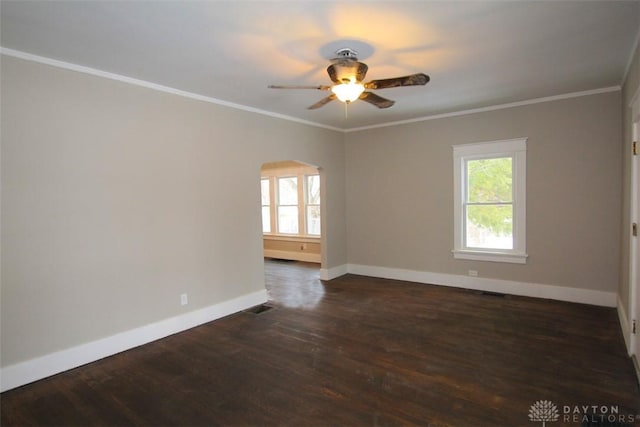 unfurnished room with dark wood-style floors, ornamental molding, and a wealth of natural light