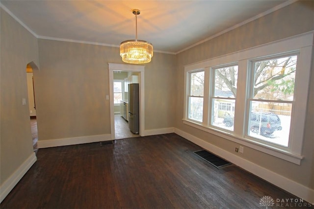 unfurnished dining area with baseboards, visible vents, arched walkways, dark wood-style floors, and crown molding