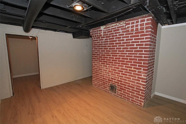 finished basement with brick wall and wood finished floors