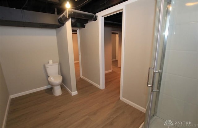 full bathroom with an enclosed shower, wood finished floors, toilet, and baseboards