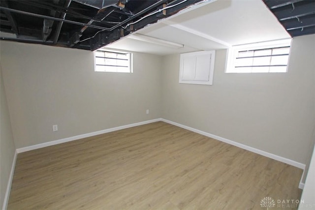 basement featuring baseboards and wood finished floors