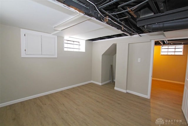 below grade area with baseboards and wood finished floors