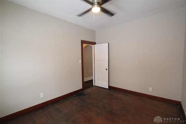 unfurnished room featuring dark wood-type flooring, visible vents, baseboards, and a ceiling fan