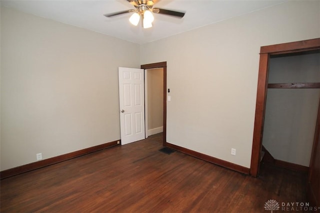 unfurnished bedroom with dark wood-type flooring, a closet, visible vents, and baseboards