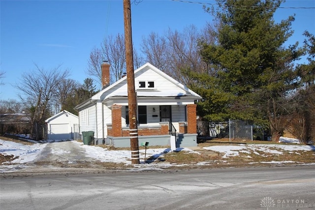 view of front of house featuring an outbuilding, a garage, and covered porch