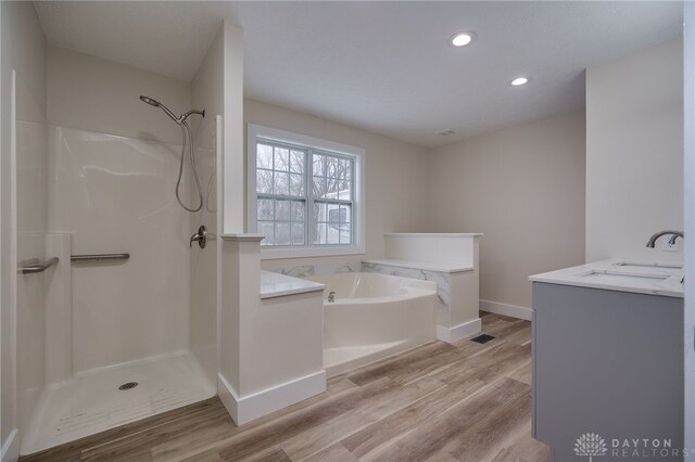 bathroom featuring vanity, hardwood / wood-style floors, and separate shower and tub