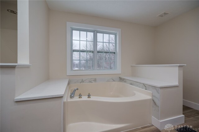 bathroom featuring a tub and hardwood / wood-style flooring