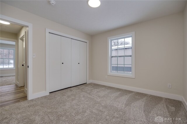 unfurnished bedroom with a closet and light carpet