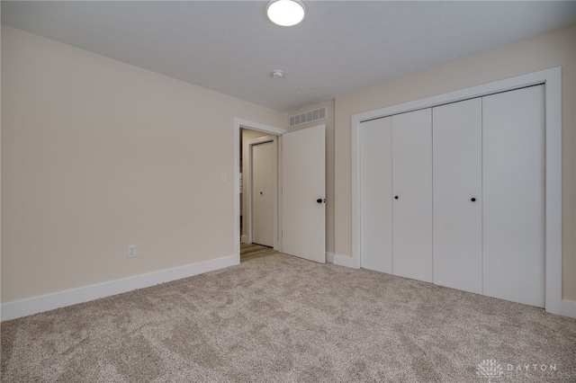 unfurnished bedroom featuring a closet and light carpet